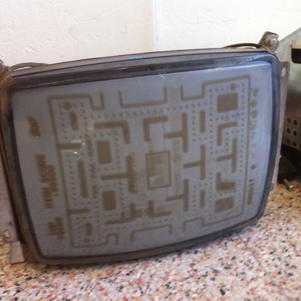 An old CRT TV screen with Pac-Man burnt onto it