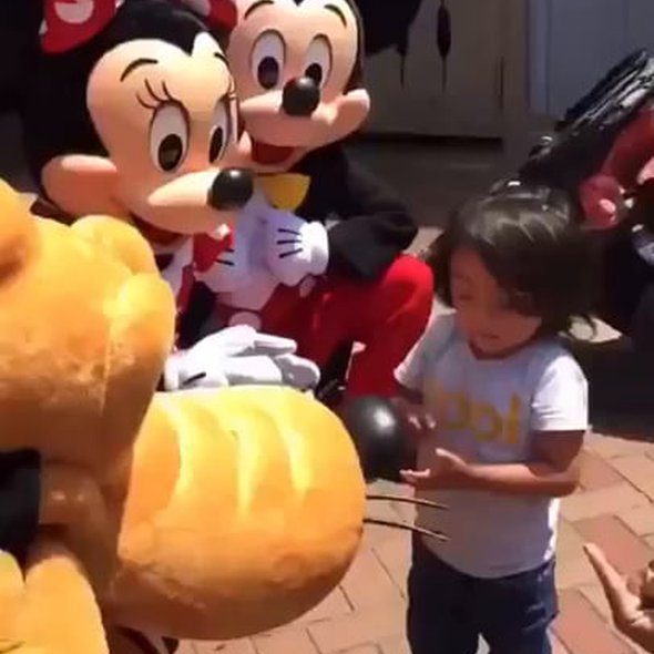 Mickey and Minnie Mouse sign to a deaf child at Disneyland... His reaction is priceless. Credit: YT/ Olive Crest